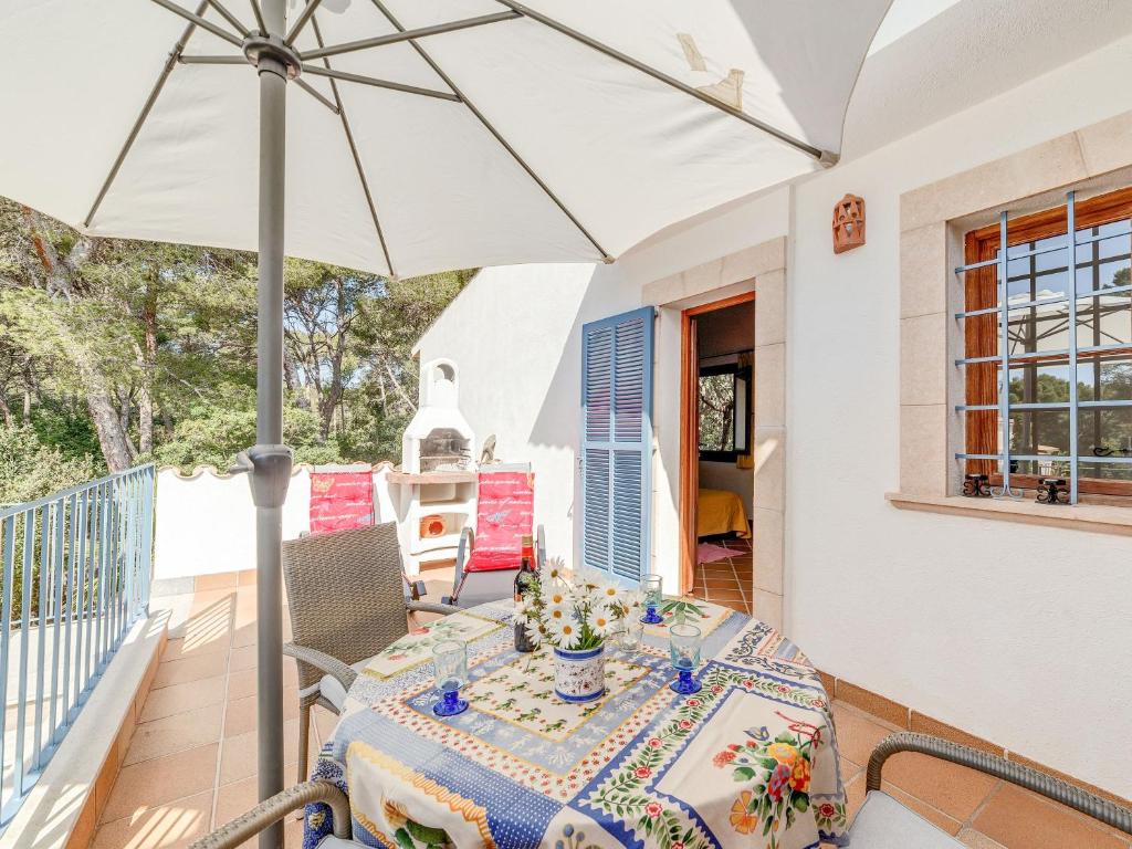 a patio with a table and an umbrella at Es Romaní in Cala Ratjada