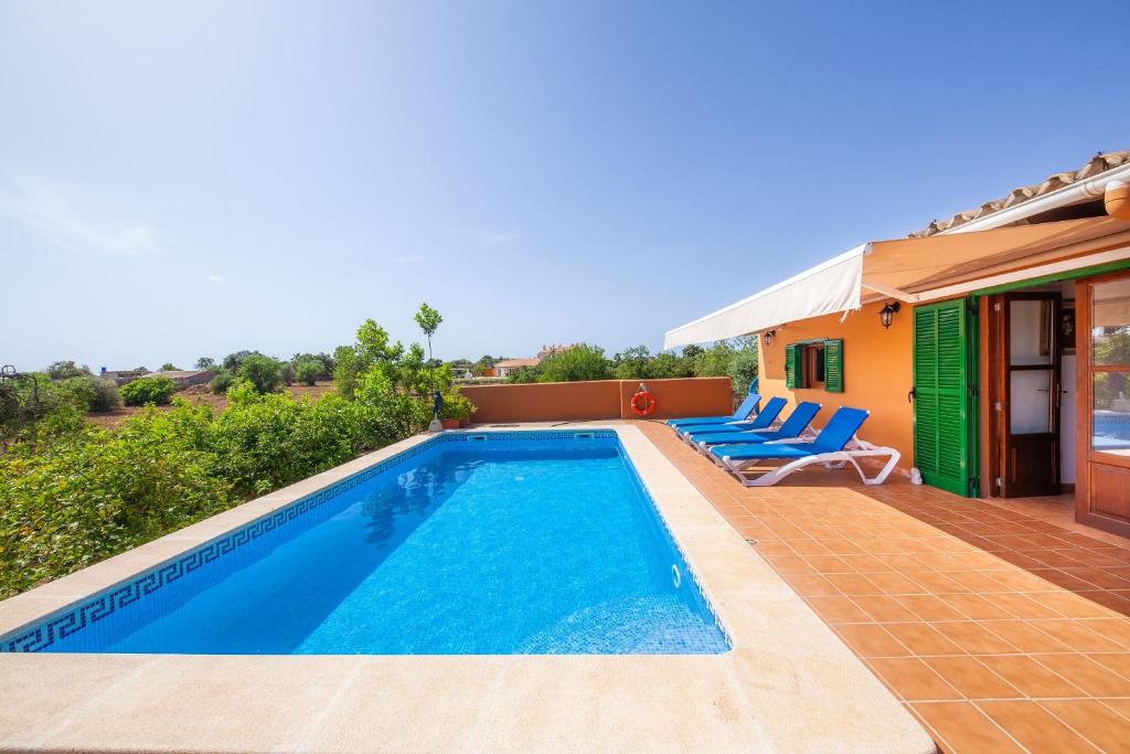 una piscina con sillas y una casa en Ses Salines cottage with private pool and barbecue, en Ses Salines