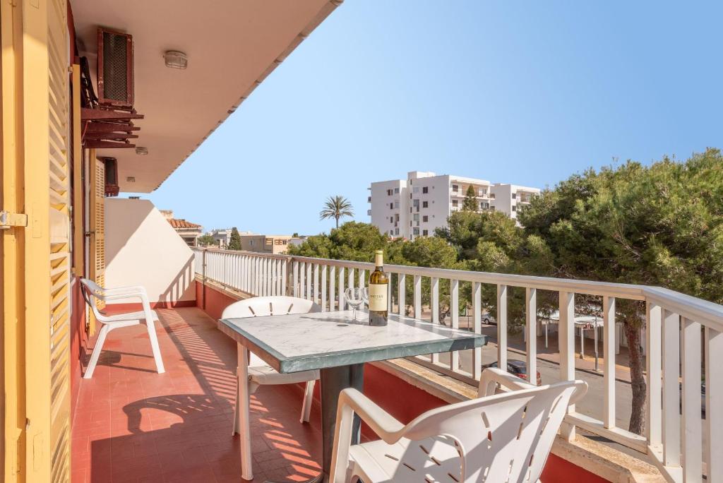 a balcony with a table and a bottle of wine at Apartamento Portosun Cornet in Portocolom