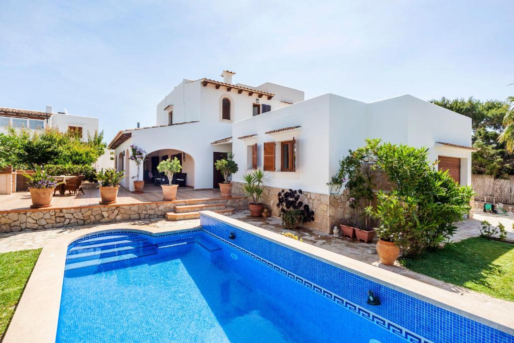 uma villa com piscina em frente a uma casa em Villa Dos Estels em Cala d´Or