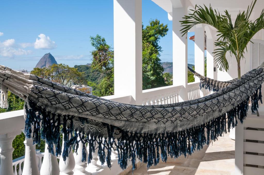 a hammock on a balcony with a view of the ocean at Prestige Property - Da Costa in Rio de Janeiro