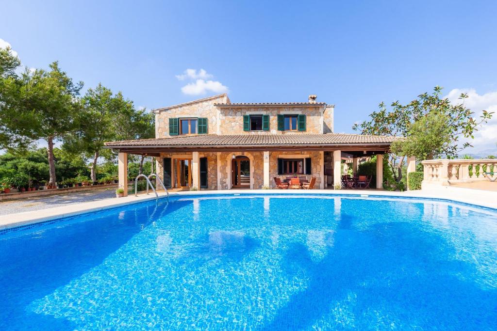 a large swimming pool in front of a house at Finca Hort des Xilindro in Alcudia