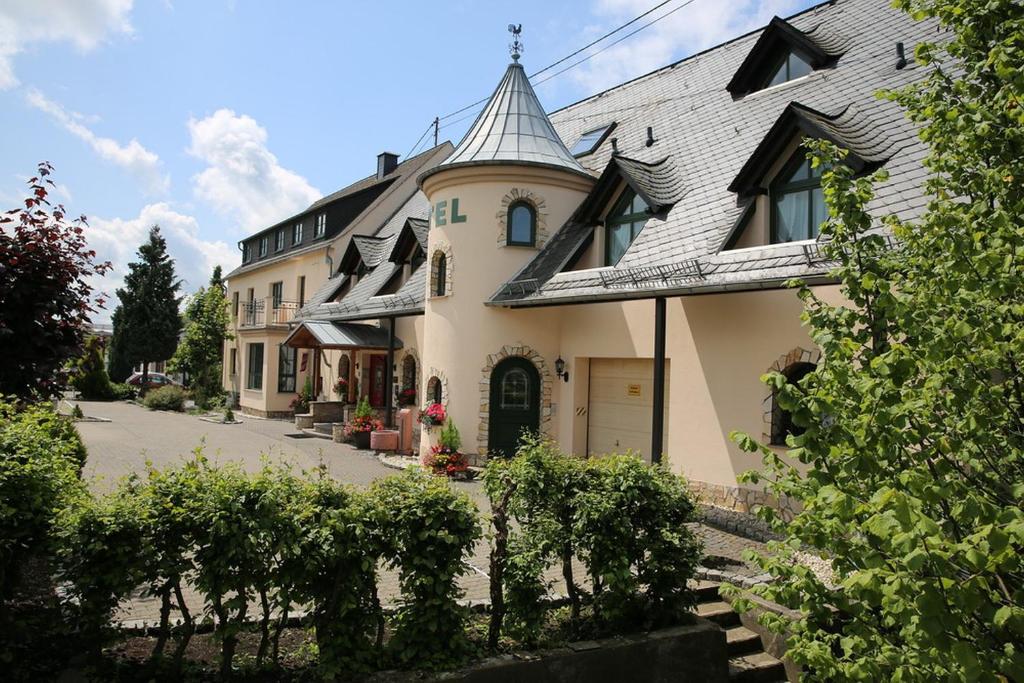 una gran casa amarilla con techo gris en Landhotel Villa Moritz garni, en Oberahr