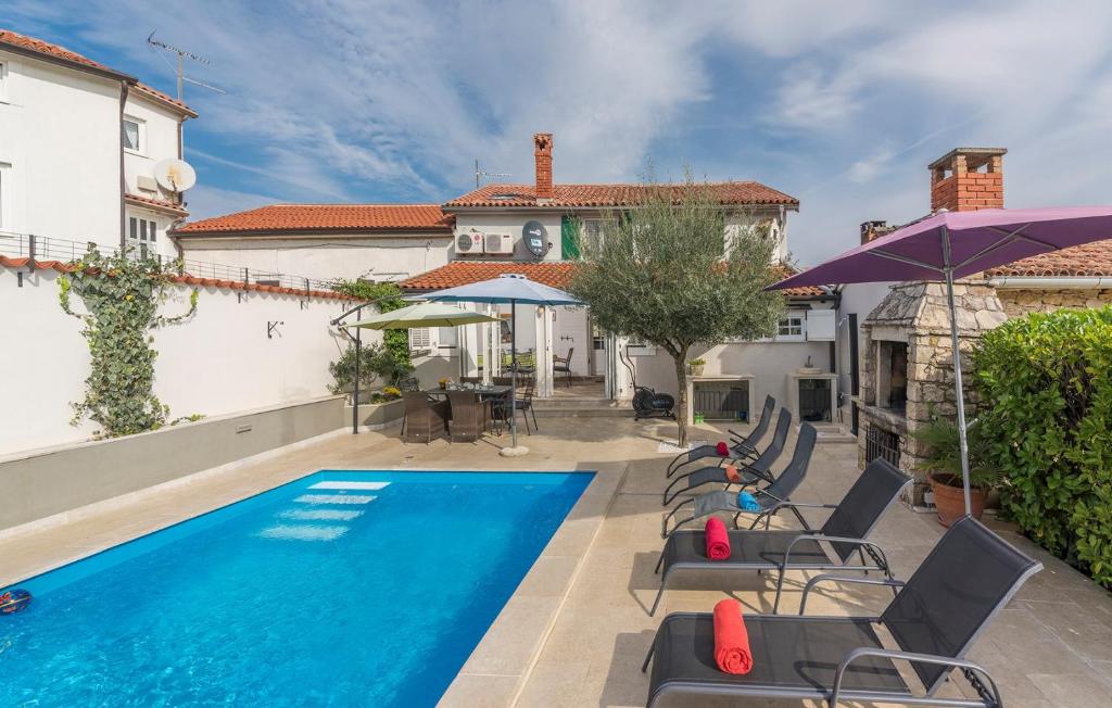 a swimming pool with chairs and a house at Casa Maura in Vižinada