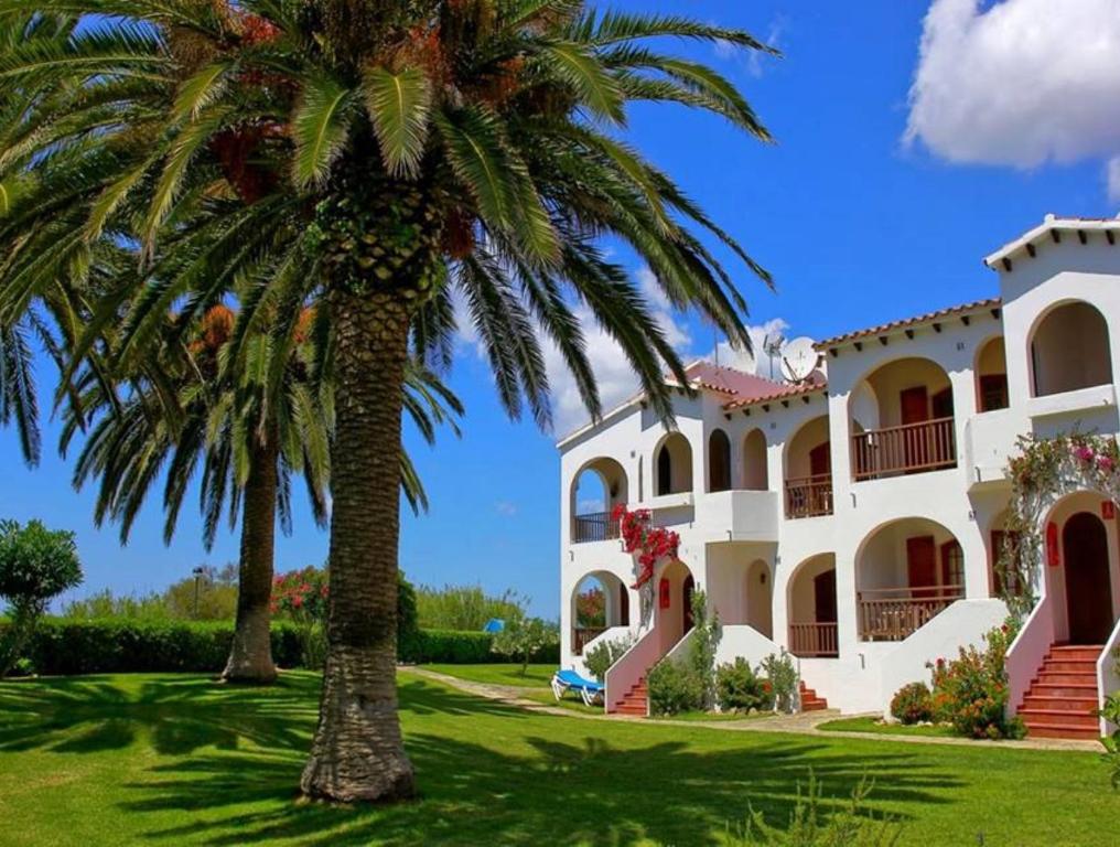 a large house with palm trees in front of it at Girasol Garden Superior 2-c in Son Bou