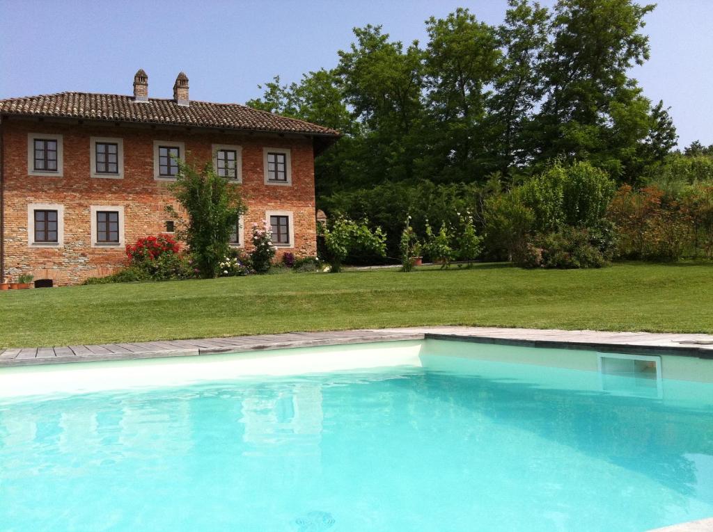 une grande piscine en face d'une maison dans l'établissement B&B Cascina Gaione Via Gallina,18b 12052 Neive cn, à Neive