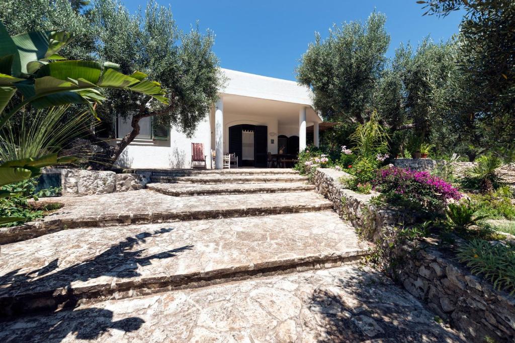 uma casa com um caminho de pedra para o jardim da frente em Villa Azzurra em Corsano
