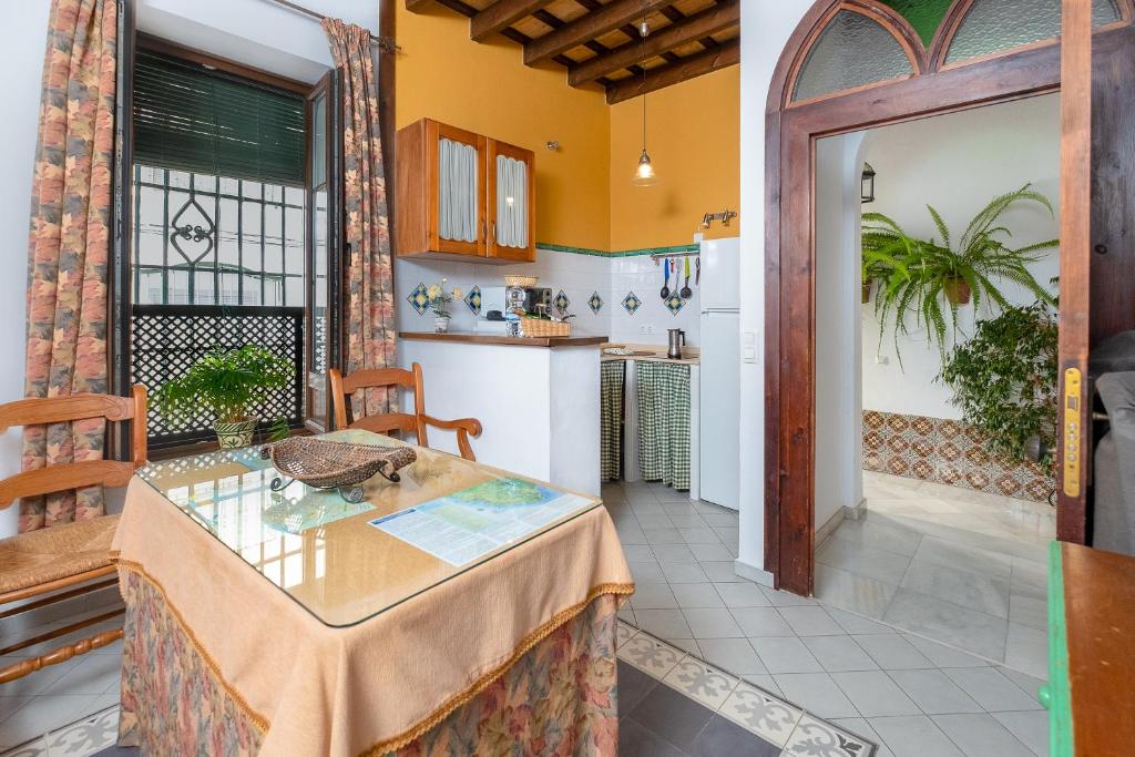 a living room with a table and a kitchen at Casa Pepa in Conil de la Frontera