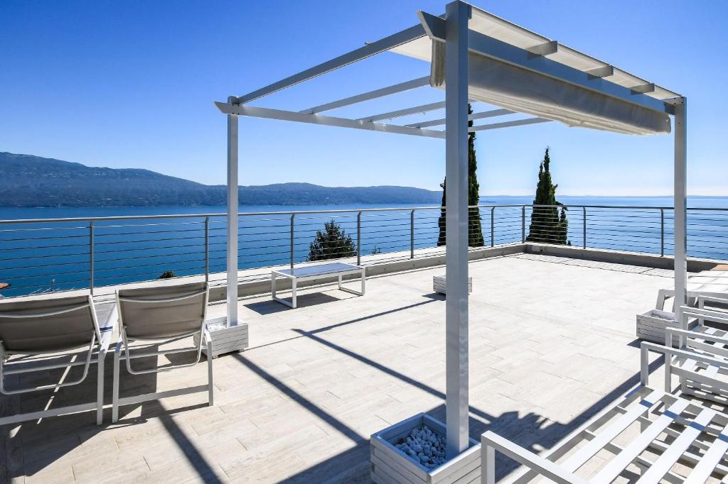 una terraza con sillas y una pérgola con vistas al agua en Appartamento Luxury 2, en Pulciano