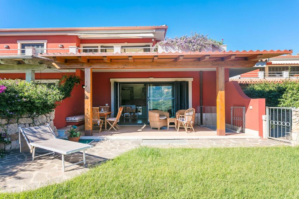 un patio con pergolato, tavolo e sedie di Residenza Fiorella a San Pantaleo