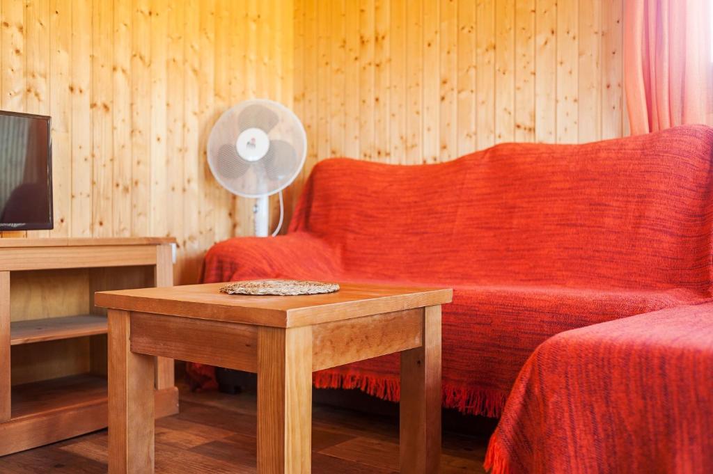 a living room with a red couch and a table at Las tres hermanas in Conil de la Frontera