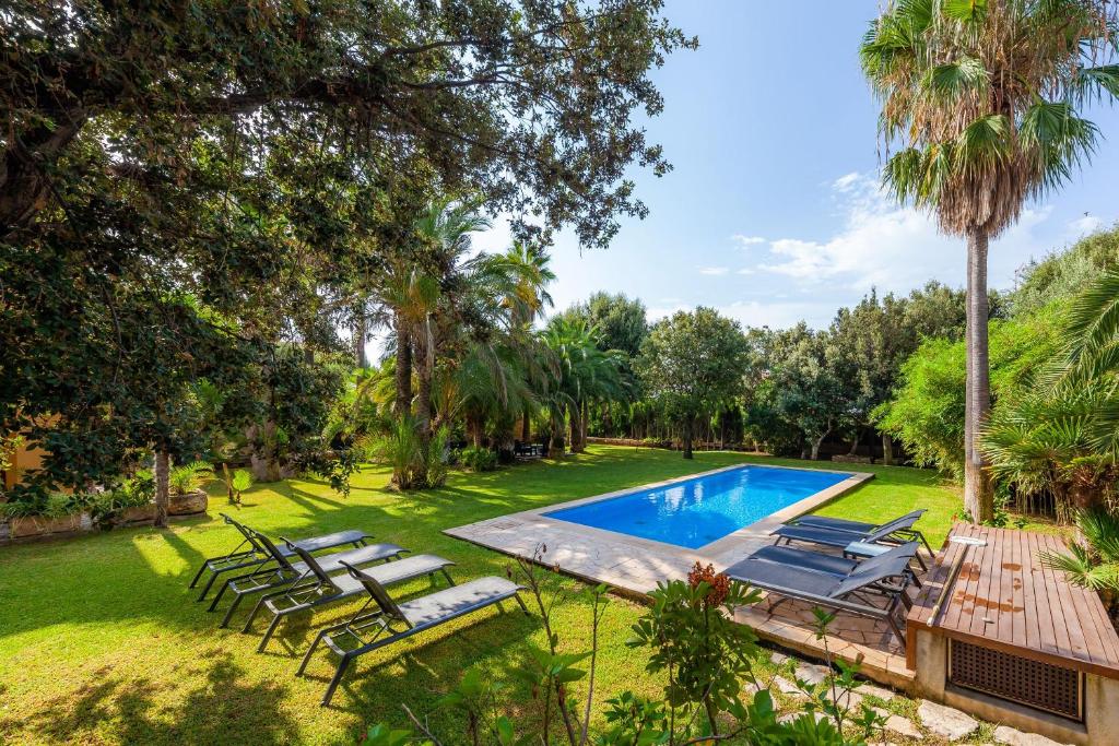 ein Bild eines Hinterhofs mit Pool und Stühlen in der Unterkunft Villa Cala Bona in Cala Bona