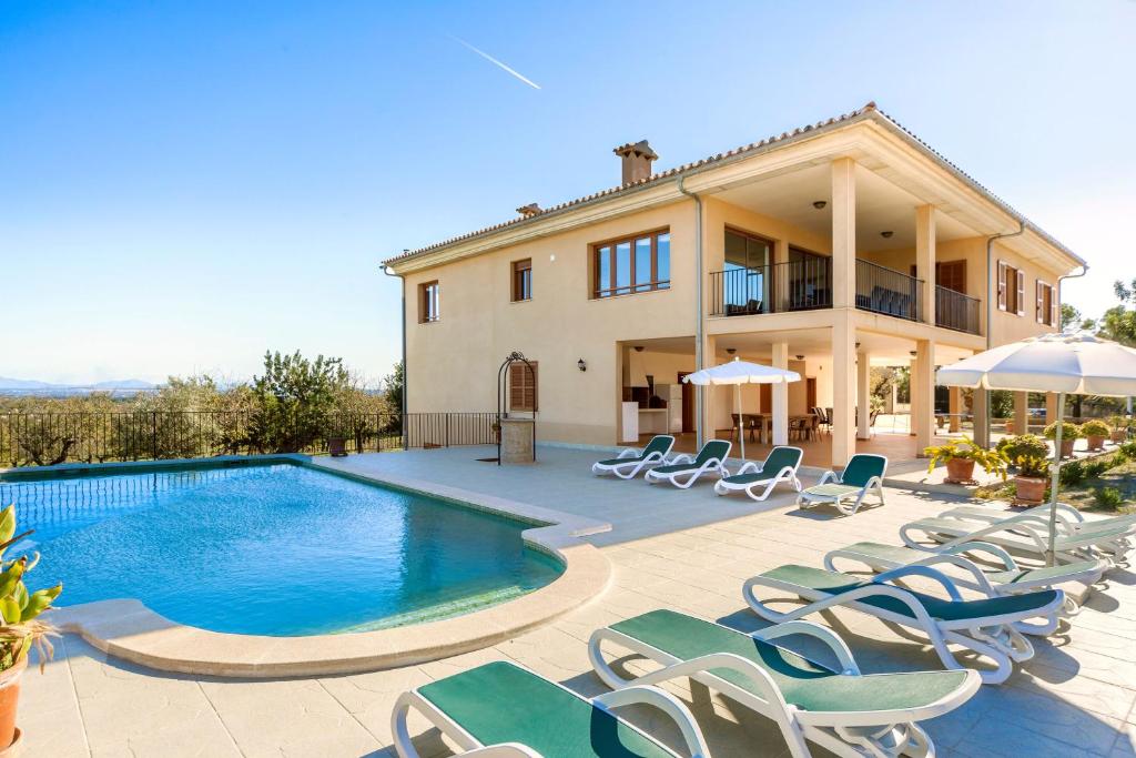 een villa met een zwembad en ligstoelen bij Villa Sastre in Moscari