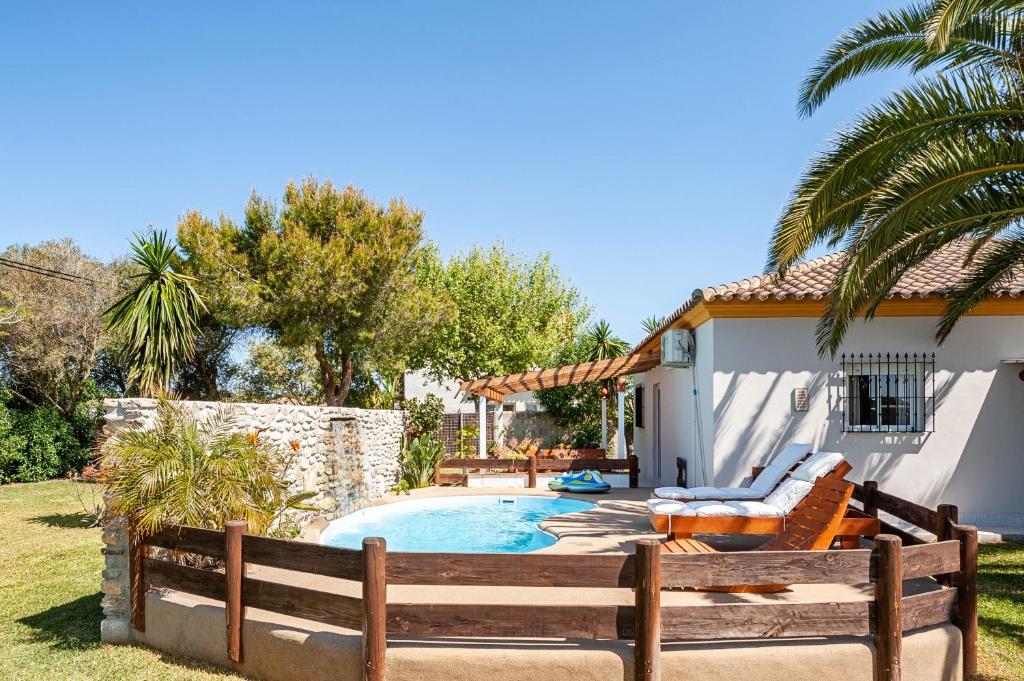 a backyard with a pool and a wooden fence at Casa-4 Mar y Arena in Barbate