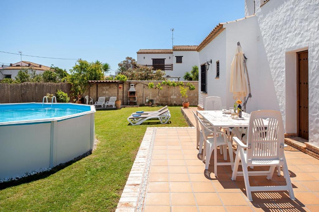 a patio with a table and chairs next to a swimming pool at El Mirador de Castilnovo in El Palmar