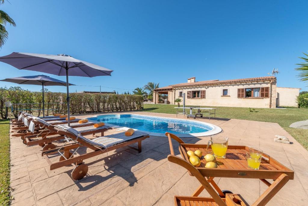 una imagen de una piscina con mesas y sombrillas en Can Siurell, en Artà