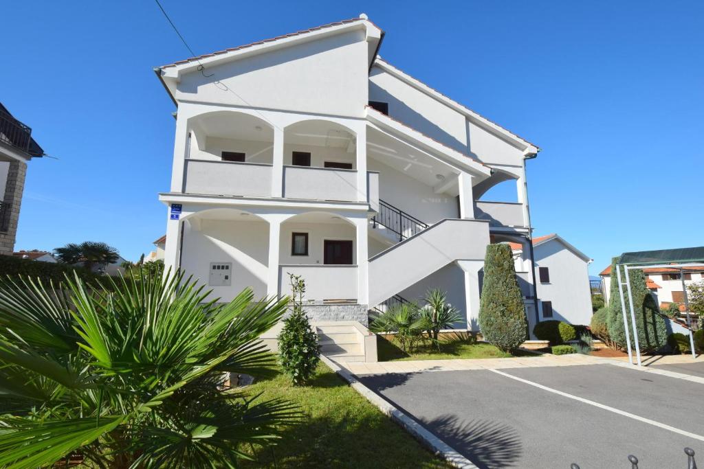 une maison blanche avec beaucoup de plantes dans l'établissement Apartment Zdenka, à Njivice