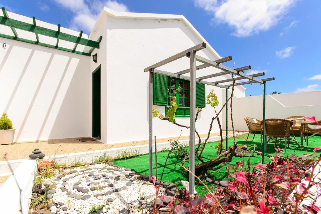 a garden with a pergola and a house at Casa Angeles 2 in Mozaga