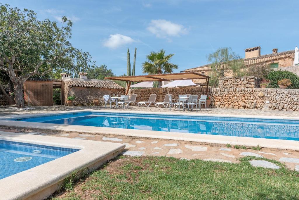 a swimming pool in a yard next to a house at Es Rafal Roig - Es Galiner in Sant Llorenç des Cardassar