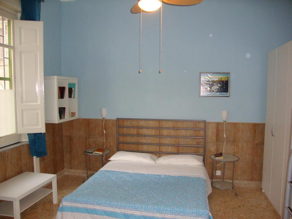 1 dormitorio con cama y pared azul en La Maison des Livres, en Reggio Calabria