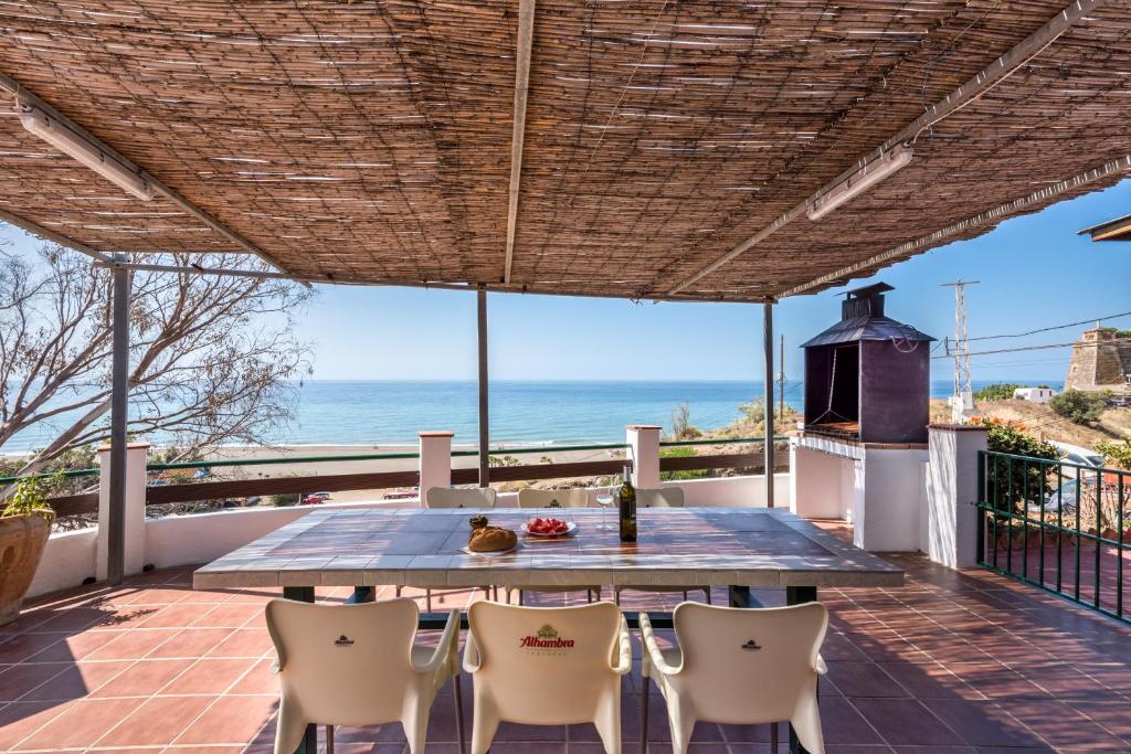 stół i krzesła na patio z widokiem na ocean w obiekcie Casa del Pipa con vistas al mar w mieście Benajarafe