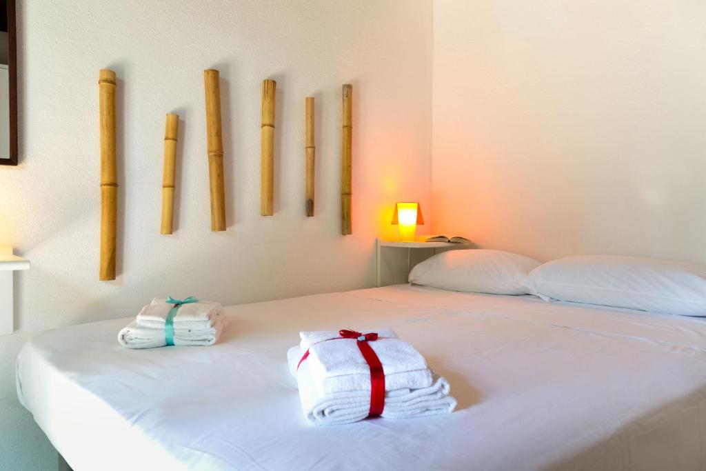 una camera da letto con due asciugamani su un letto con mazze sul muro di Coccinella a San Teodoro