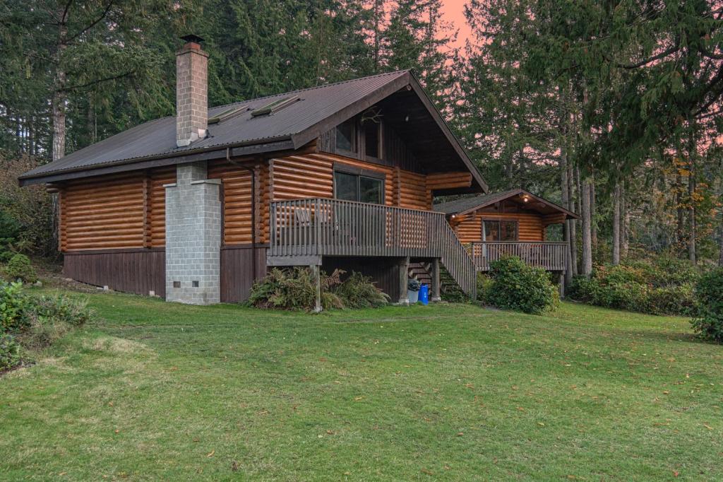 a log cabin with a large yard in front of it at Cusheon Lake Resort in Ganges
