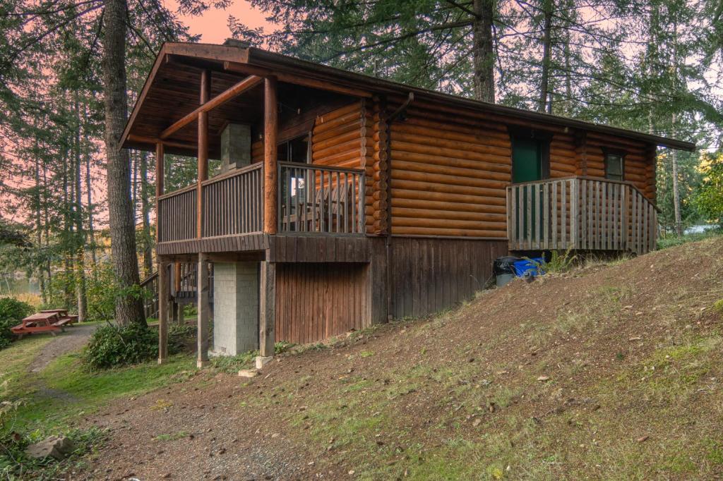 a log cabin on a hill in the woods at Cusheon Lake Resort in Ganges