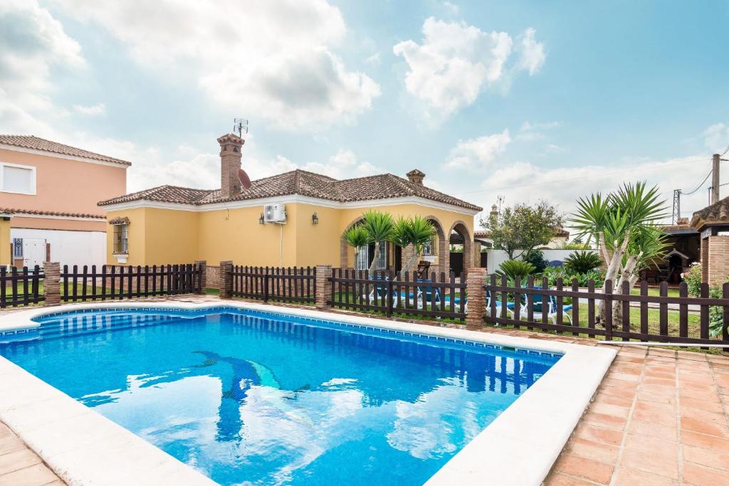 a swimming pool in front of a house at Casa Familiar La Lobita 1 in Conil de la Frontera