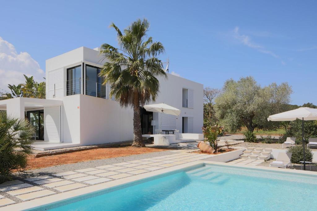 eine Villa mit einem Swimmingpool vor einem Haus in der Unterkunft Sa Plana d´en Miquel in Sant Joan de Labritja