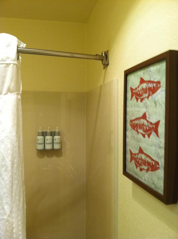 a bathroom with a shower with a painting of fish at The Redwood Riverwalk, a boutique hotel in Fortuna