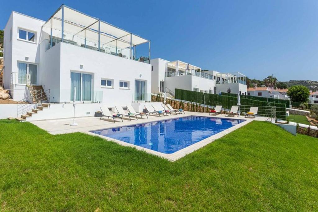 une villa avec piscine devant une maison dans l'établissement Villa Sunrise, à Son Bou