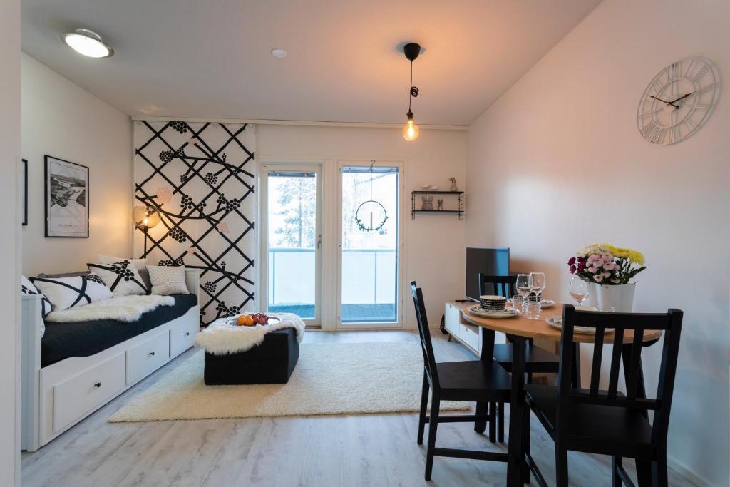 een slaapkamer met een bed en een tafel en een eetkamer bij Tuomas´ luxurious suites, Mustikka in Rovaniemi