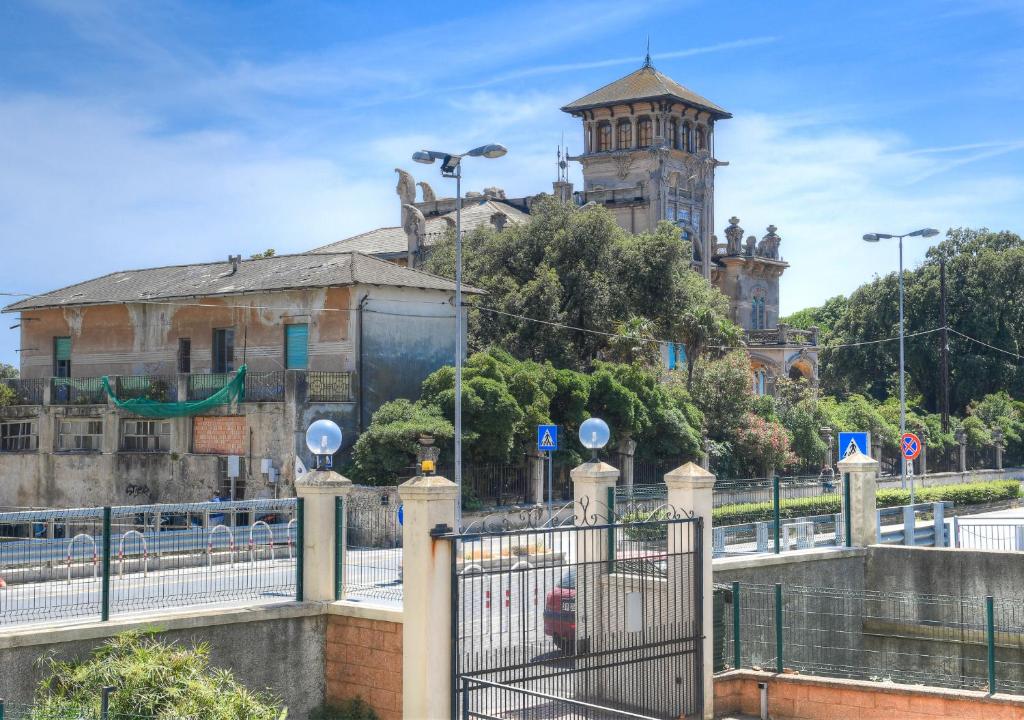 a gate in front of a building with a tower at La Conchiglia in Savona