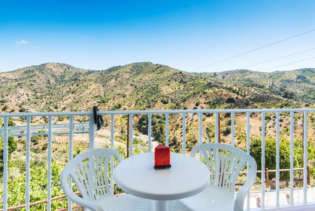 una mesa blanca y sillas en un balcón con montañas en Apartamento Rural De Oses 2 en Tolatán