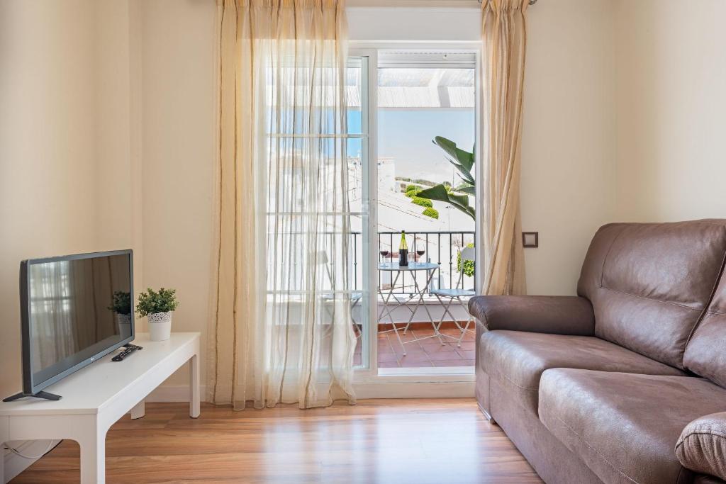 a living room with a couch and a tv at House Sun Beach 2 in Vejer de la Frontera