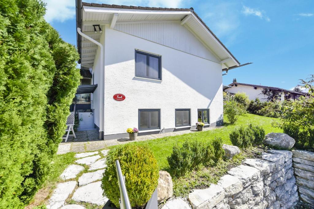 a white house with a stone wall at Fewo Trudi in Grabenstätt