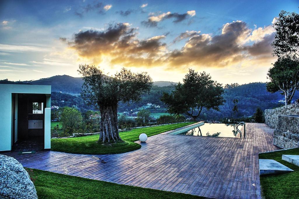 a garden with a tree and a house at Quinta Da Mouta in Vieira do Minho