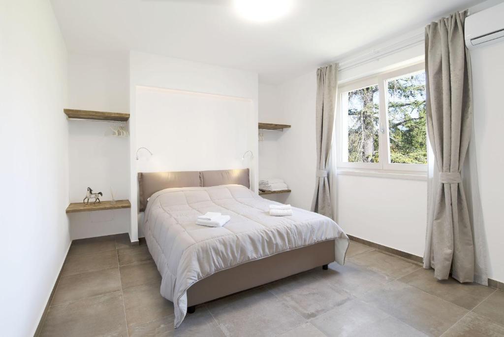 a bedroom with a bed and a window at Appartamenti Dama 1 in Bardolino