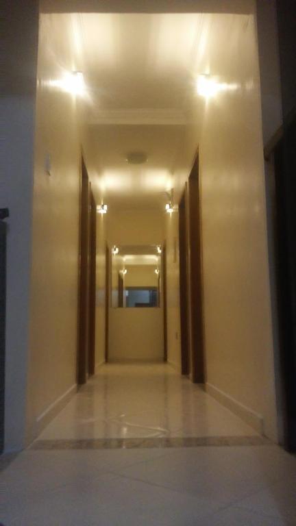un pasillo vacío con dos puertas y un espejo en Casa e Suites, en Aparecida