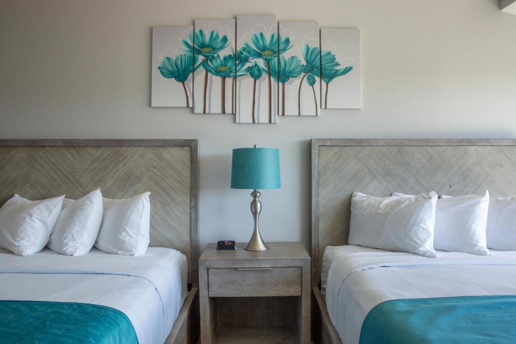 a hotel room with two beds and a table with a lamp at Athens Central Hotel in Athens