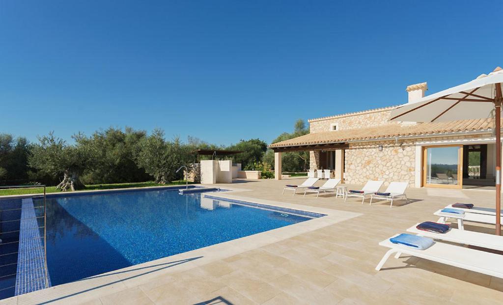 uma villa com uma piscina e uma casa em Sa Garriga em Ariany