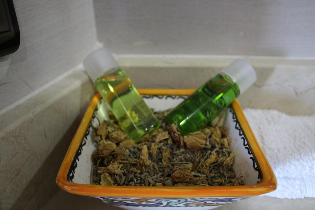 a container filled with nuts and a green bottle at Le temps perdu in Oualidia