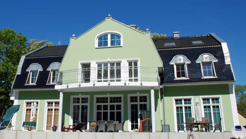 a green and white house with a black roof at Gutshaus_Appartements mit Kamin_ S in Coldevitz