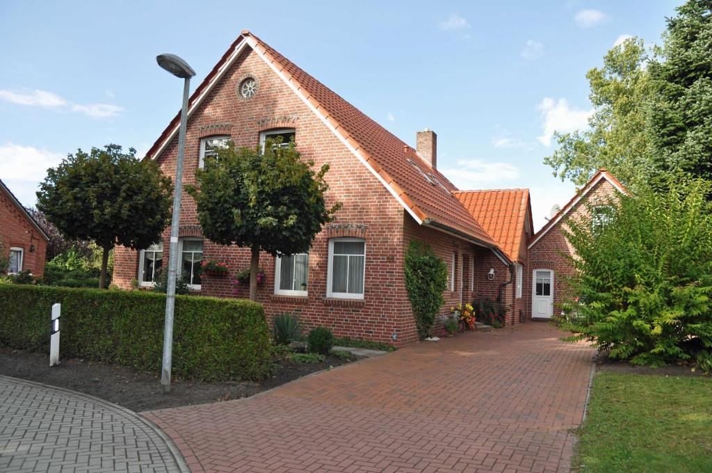 a red brick house with a brick driveway at Ferienwohnung Anni, 65325 in Moormerland