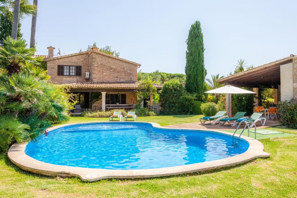 a swimming pool in the yard of a house at Villa Can Curt in Pollença