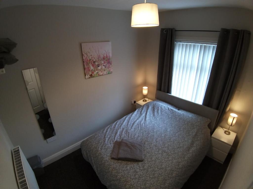 ein kleines Schlafzimmer mit einem Bett und einem Fenster in der Unterkunft Templemore Townhouse in Belfast