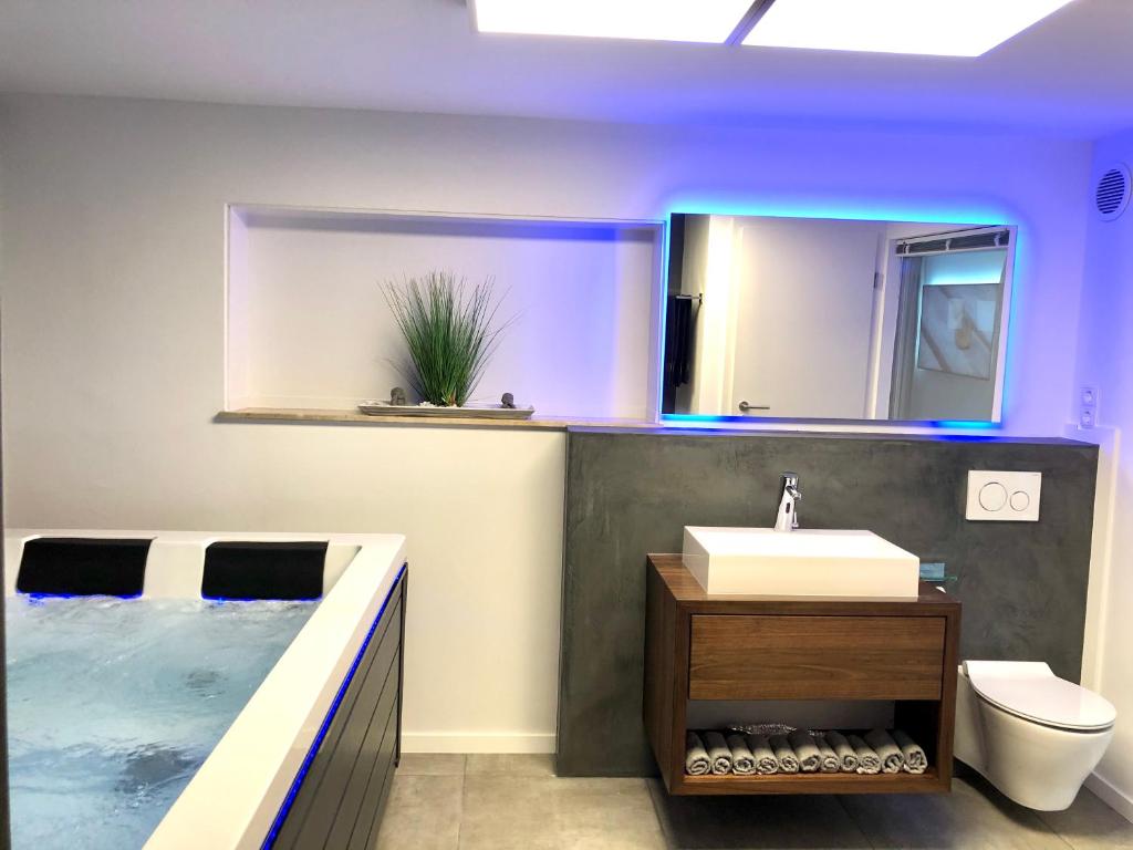 ein Bad mit einem Waschbecken und einem Pool in der Unterkunft Luxus Spa auf tollem Anwesen in Neubulach