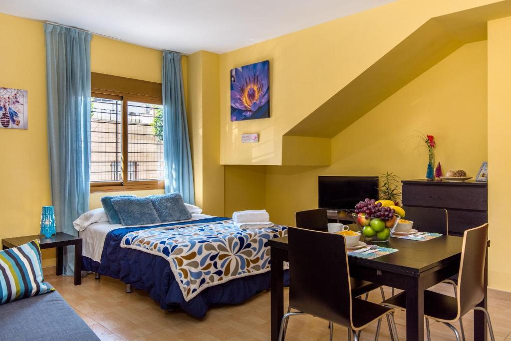 a bedroom with a bed and a dining room at Apartamento estudio in Málaga