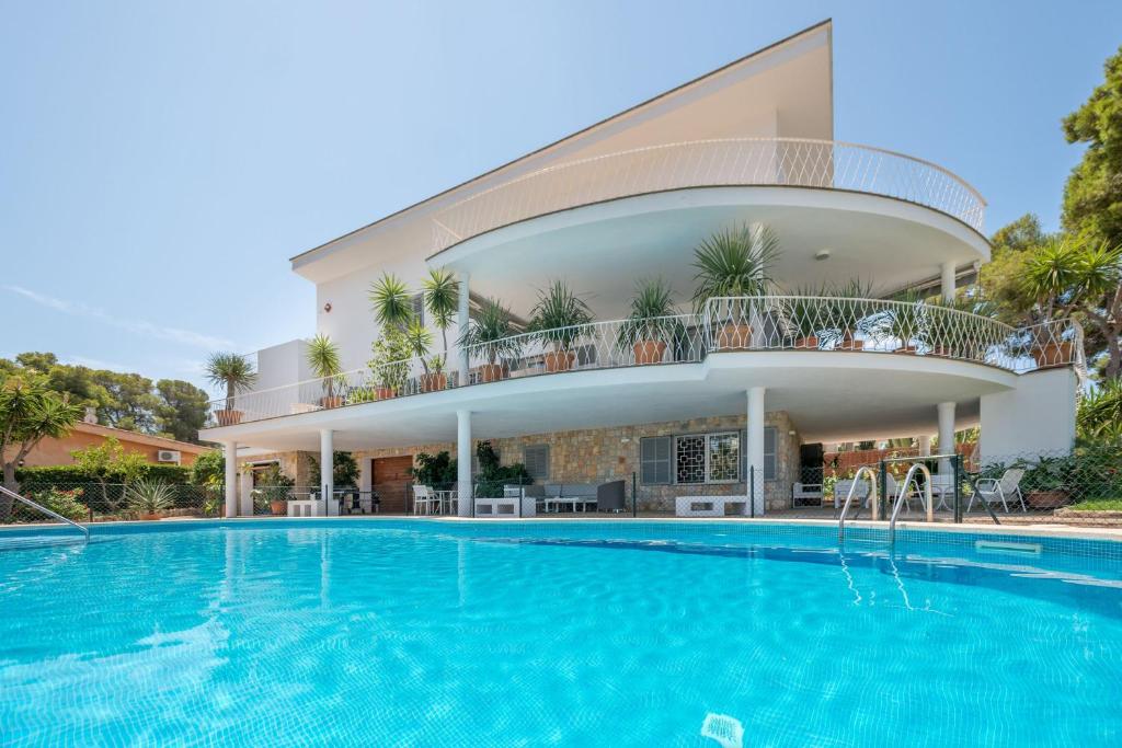 a villa with a swimming pool in front of a building at Villa Son Veri de la Marina in El Arenal